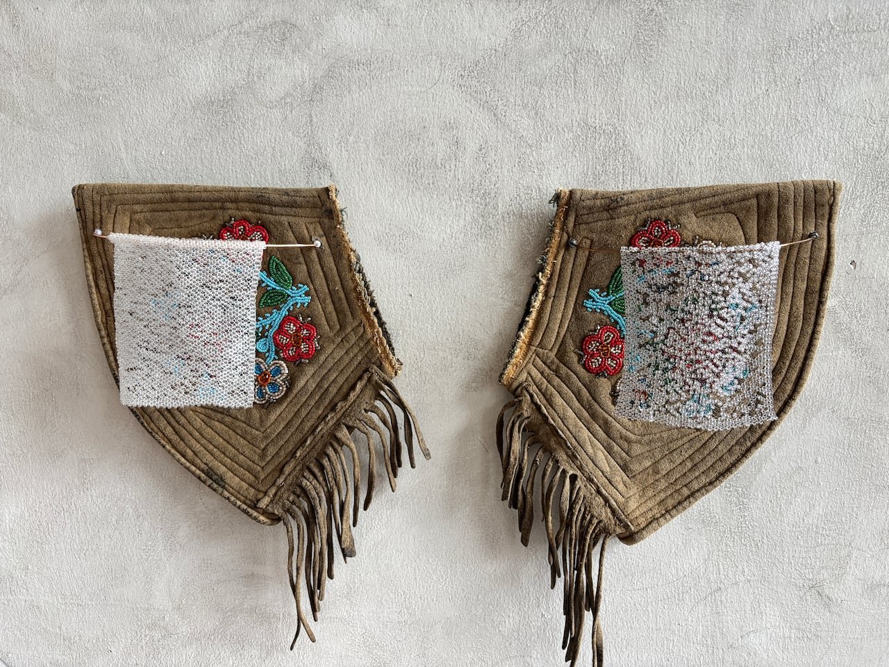 Two beaded leatherworks.