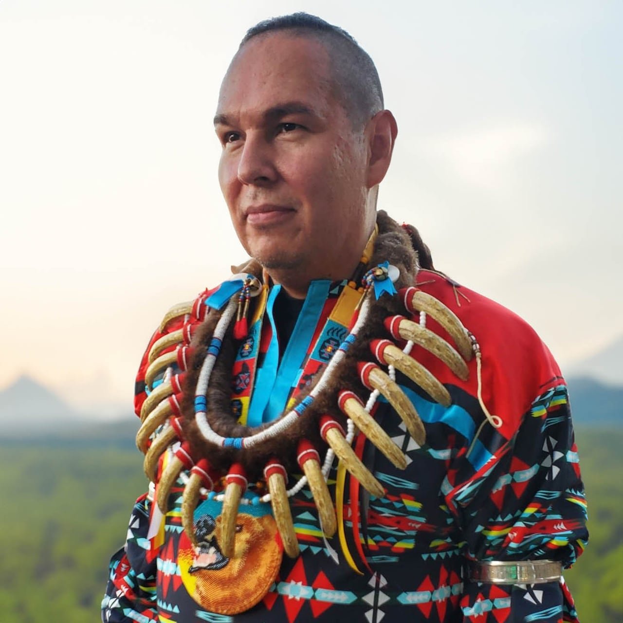 Man in traditional regalia, wearing (bear) claw necklace.
