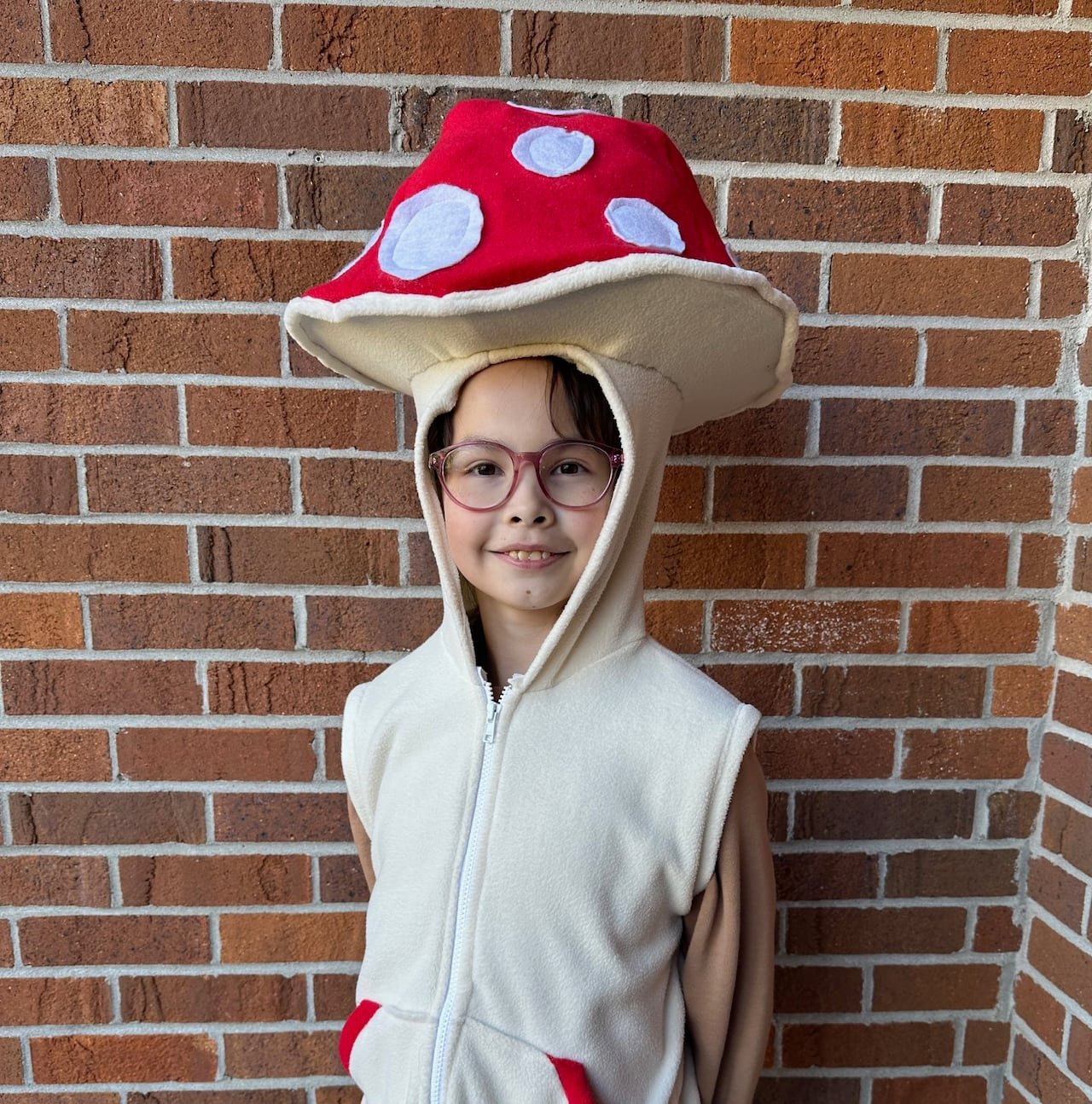 A young girl stands in a mushroom costume