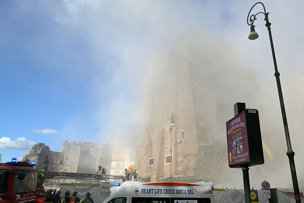 default-322 Dust billows from a historic brick tower as rescue works crawl on a diagonal crane from the truck to a window.
